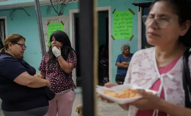 Estrella Bejarano, second from left, the mother of two children who died after a rain-induced landslide, speaks with relatives in Naucalpan, Mexico, Tuesday, Sept. 17, 2024. (AP Photo/Felix Marquez)