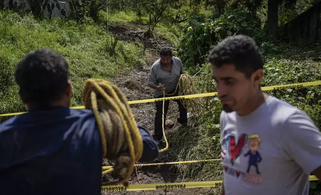 Residents volunteer at the site where various people died after a rain-induced landslide, in Naucalpan, Mexico, Tuesday, Sept. 17, 2024. (AP Photo/Felix Marquez)