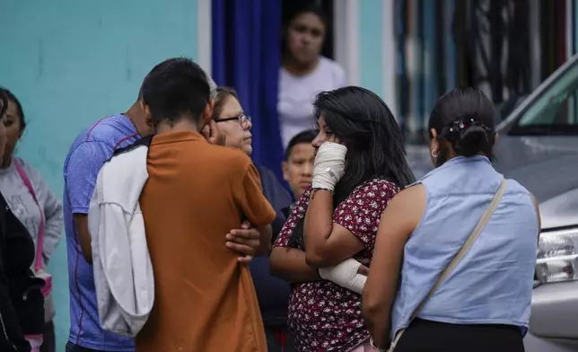 Estrella Bejarano, second from right, the mother of two children who died after a rain-induced landslide, speaks with relatives in Naucalpan, Mexico, Tuesday, Sept. 17, 2024. (AP Photo/Felix Marquez)