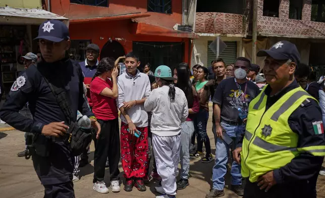 Residents gather near the site where various were buried after a landslide caused by rains, in Naucalpan, Mexico, Tuesday, Sept. 17, 2024. (AP Photo/Felix Marquez)