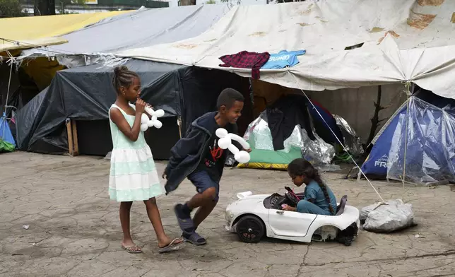 FILE - Young Brazilian migrants play in a tent encampment set up by migrants near the North Bus Station in Mexico City, June 27, 2024. (AP Photo/Marco Ugarte, File)