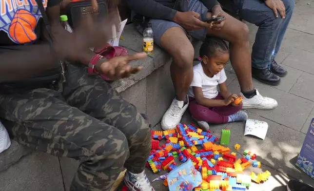 A Colombian migrant child plays with plastic construction toys at a migrant tent encampment set up on the plaza of the Santa Cruz y La Soledad Catholic parish church Mexico City, Monday, July 8, 2024. (AP Photo/Marco Ugarte)