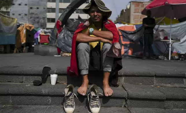 FILE - Venezuelan migrant Cristo Perez sits in the sun at a migrant camp on the perimeters of the Santa Cruz y La Soledad Catholic parish church, in La Merced neighborhood of Mexico City, July 31, 2024. (AP Photo/Marco Ugarte, File)