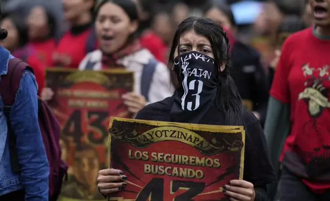 Families and friends take part in a demonstration marking the 10-year anniversary of the disappearance of 43 students from an Ayotzinapa rural teacher's college, in Mexico City, Thursday, Sept. 26, 2024. (AP Photo/Eduardo Verdugo)