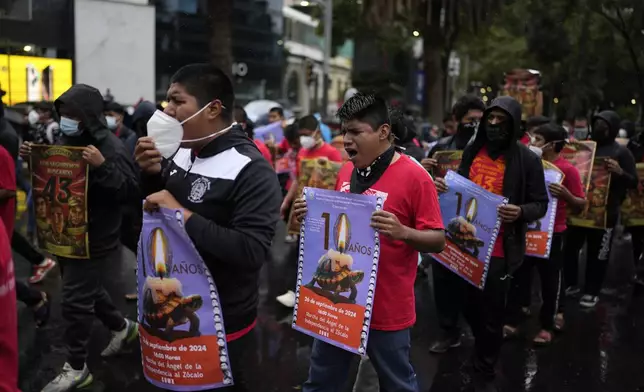 Families and friends take part in a demonstration marking the 10-year anniversary of the disappearance of 43 students from an Ayotzinapa rural teacher's college, in Mexico City, Thursday, Sept. 26, 2024. (AP Photo/Eduardo Verdugo)