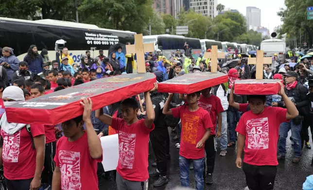 Youth holding mock coffins take part in a demonstration marking the 10-year anniversary of the disappearance of 43 students from an Ayotzinapa rural teacher's college, in Mexico City, Thursday, Sept. 26, 2024. (AP Photo/Eduardo Verdugo)