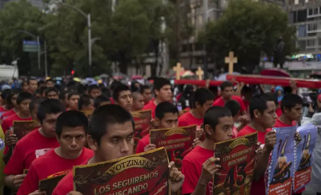 Youths take part in a demonstration marking the 10-year anniversary of the disappearance of 43 Ayotzinapa rural teacher's college students, in Mexico City, Thursday, Sept. 26, 2024. (AP Photo/Jon Orbach)