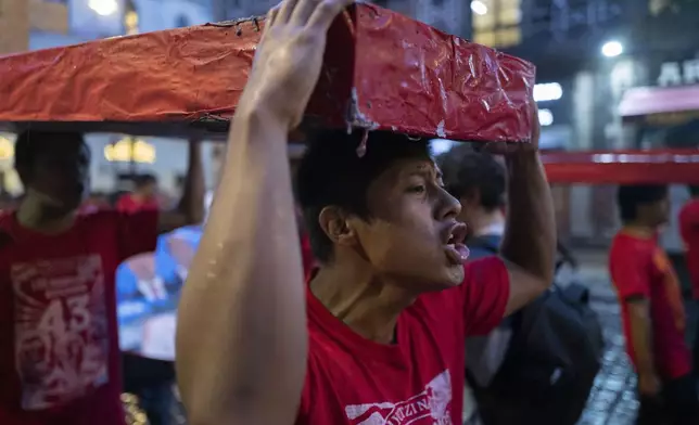 Youth holding mock coffins take part in a demonstration marking the 10-year anniversary of the disappearance of 43 Ayotzinapa rural teacher's college students, in Mexico City, Thursday, Sept. 26, 2024. (AP Photo/Jon Orbach)