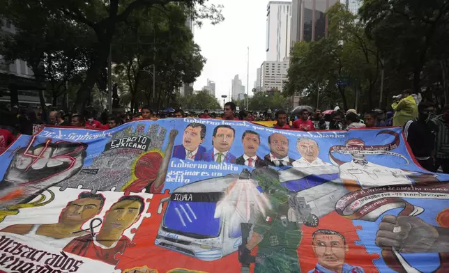 Families and friends take part in a demonstration marking the 10-year anniversary of the disappearance of 43 students from an Ayotzinapa rural teacher's college, in Mexico City, Thursday, Sept. 26, 2024. (AP Photo/Fernando Llano)