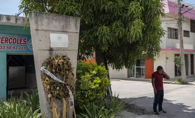 Ulises Martinez, a former student of the Raúl Isidro Burgos Rural Normal School, stands at a monument honoring his slain schoolmates Julio Cesar Ramirez and Daniel Solis Gallardo, at the site where their bodies were recovered 10 years prior in Iguala, Mexico, Saturday, Sept. 7, 2024. (AP Photo/Felix Marquez)