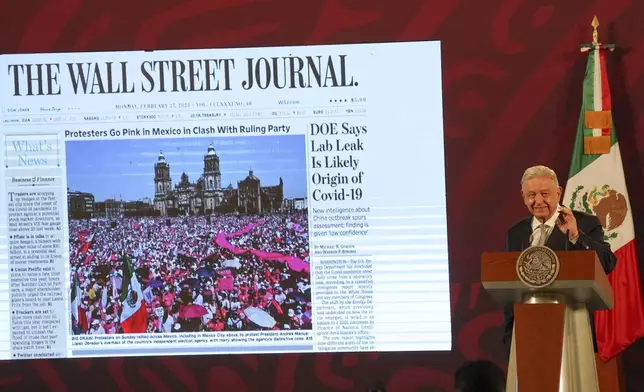 FILE - Mexican President Andres Manuel Lopez Obrador shows the front page of The Wall Street Journal, featuring a story about opposition to his electoral law changes, during his regularly scheduled morning press conference at the National Palace in Mexico City, Feb. 28, 2023. (AP Photo/Marco Ugarte, File)