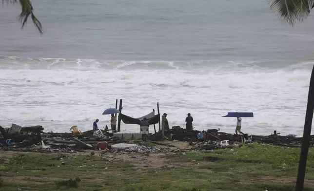 Residents cull for personal items in the debris scattered along the shore in the aftermath of Hurricane John, in Acapulco, Mexico, Friday, Sept. 27, 2024. (AP Photo/Bernardino Hernandez)