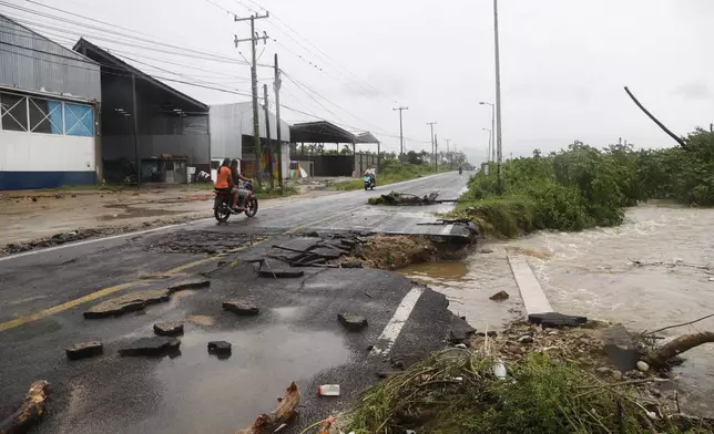 A motorcyclist rides by a street damaged during the passing of Hurricane John, in Acapulco, Mexico, Friday, Sept. 27, 2024. (AP Photo/Bernardino Hernandez)