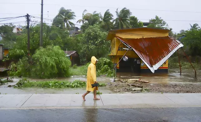 A person walks in the rain after the passing of Hurricane John in Marquelia, Mexico, Tuesday, Sept. 24, 2024. (AP Photo/Luis Alberto Cruz)