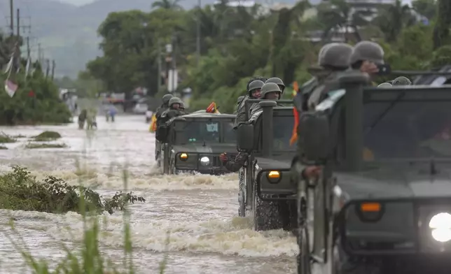 A caravan of Army vehicles make their way through a street flooded by the passing of Hurricane John, in Acapulco, Mexico, Friday, Sept. 27, 2024. (AP Photo/Bernardino Hernandez)