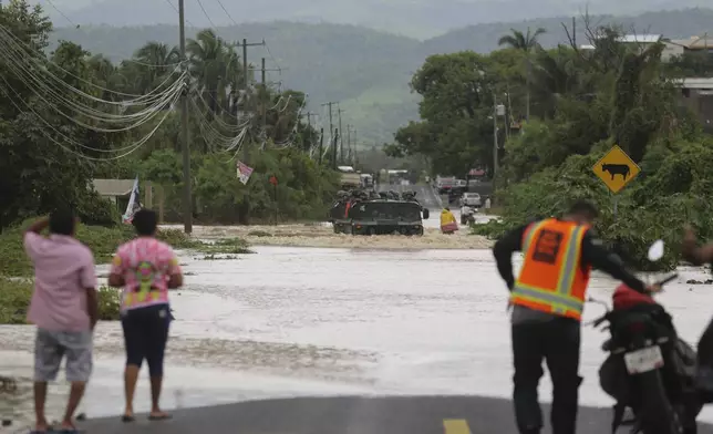 An army vehicle negotiates a street flooded by the passing of Hurricane John, in Acapulco, Mexico, Friday, Sept. 27, 2024. (AP Photo/Bernardino Hernandez)