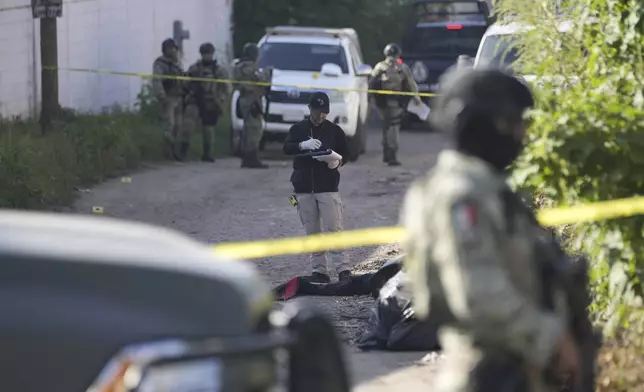 Forensic investigators work at the site of a body lying in the street in La Costerita, Culiacan, Sinaloa state, Mexico, Thursday, Sept. 19, 2024. (AP Photo/Eduardo Verdugo)