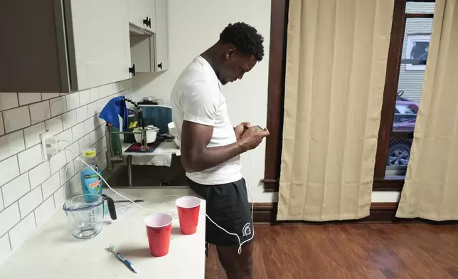 Armorion Smith, an NCAA football player at Michigan State, watches game video on his phone at home in Lansing, Mich., Tuesday, Sept. 3, 2024. (AP Photo/Paul Sancya)