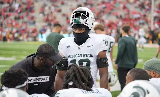 Michigan State defensive back Armorion Smith, right, listens as secondary coach Blue Adams, left, talks to players on the sidelines during the first half of an NCAA college football game against Maryland, Saturday, Sept. 7, 2024, in College Park, Md. (AP Photo/Stephanie Scarbrough)