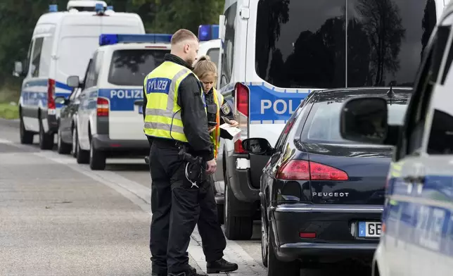 German police check the details of a French car near the border to Belgium in Aachen, Germany, Monday, Sept. 16, 2024, as Germany begins carrying out checks at all its land borders. (AP Photo/Martin Meissner)