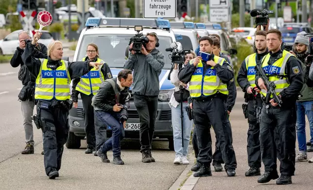 A German police officer stops a bus at the border between Germany and France, in Kehl, Germany, Monday, Sept. 16, 2024, as Germany begins carrying out checks at all its land borders. (AP Photo/Michael Probst)