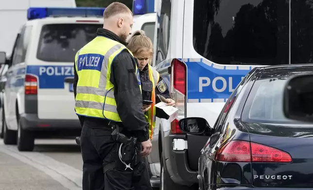 German police check the details of a French car near the border to Belgium in Aachen, Germany, Monday, Sept. 16, 2024, as Germany begins carrying out checks at all its land borders. (AP Photo/Martin Meissner)