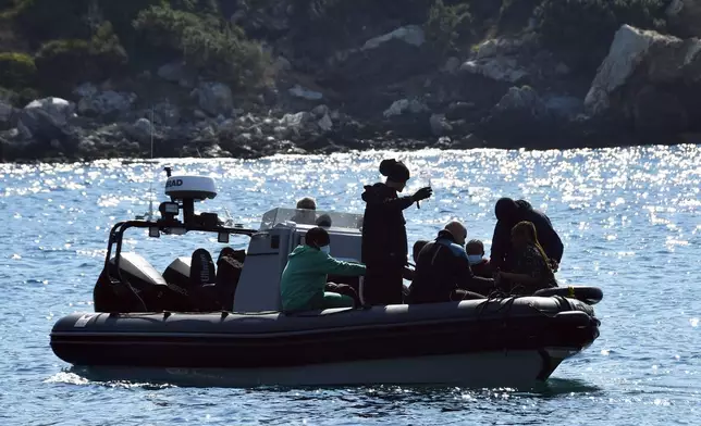 Survivors sit on a vessel after a boat carrying migrants ran into trouble off the coast of the eastern Aegean Sea island of Samos, Greece, on Monday, Sept. 23, 2024. (AP Photo/Michael Svarnias)