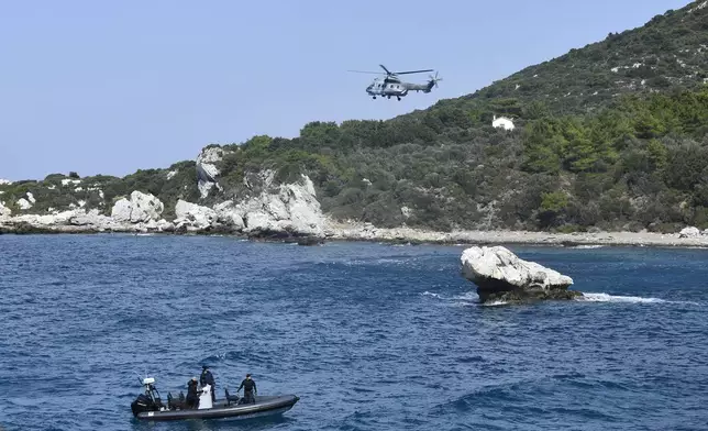 A helicopter and a vessel with coast guards officers take part in a search and rescue operation after a boat carrying migrants ran into trouble off the coast of the eastern Aegean Sea island of Samos, Greece, on Monday, Sept. 23, 2024. (AP Photo/Michael Svarnias)