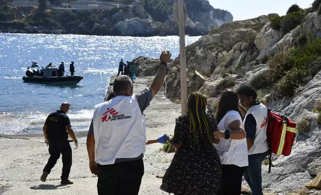 Members of Doctors Without Borders help a pregnant woman who survived after a boat carrying migrants ran into trouble off the coast of the eastern Aegean Sea island of Samos, Greece, on Monday, Sept. 23, 2024. (AP Photo/Michael Svarnias)