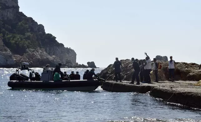 Members of Doctors Without Borders and coast guards officers help a pregnant woman to embark on a vessel with other survivors, after a boat carrying migrants ran into trouble off the coast of the eastern Aegean Sea island of Samos, Greece, on Monday, Sept. 23, 2024. (AP Photo/Michael Svarnias)