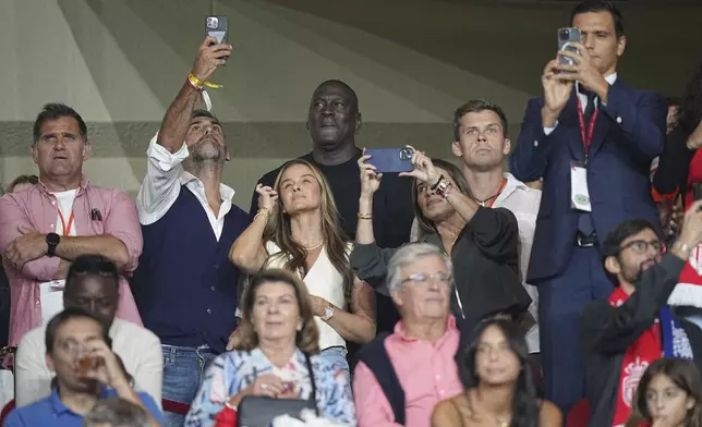 American former professional basketball player Michael Jordan, center, gestures as he poses for a selfie while attend the start of the Champions League opening phase soccer match between Monaco and Barcelona at the Louis II stadium, in Monaco, Monaco, Thursday, Sept. 19, 2024. (AP Photo/Laurent Cipriani)