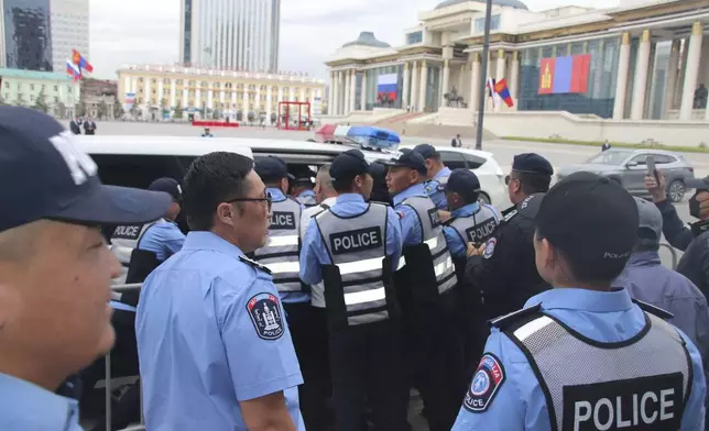 Police and security officers detain members of the "No War" group protesting the visit of Russian President Vladimir Putin in Ulaanbaatar, Mongolia, Tuesday, Sept. 3, 2024. (AP Photo/Ganbat Namjilsangarav)