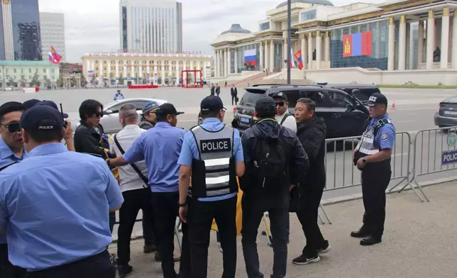 Police and security officers prevent members of the "No War" group from holding up a Ukrainian flag during the visit of Russian President Vladimir Putin in Ulaanbaatar, Mongolia, Tuesday, Sept. 3, 2024. (AP Photo/Ganbat Namjilsangarav)