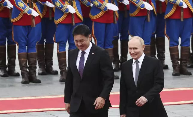 Russian President Vladimir Putin, right, walks with Mongolian President Ukhnaagiin Khurelsukh, left, during welcoming ceremony at Sukhbaatar Square in Ulaanbaatar, Mongolia, Tuesday, Sept. 3, 2024. (Sofya Sandurskaya, Sputnik, Kremlin Pool Photo via AP)