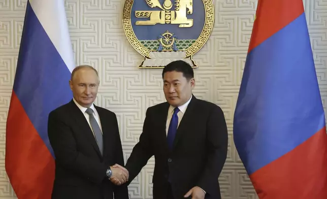 Russian President Vladimir Putin and Mongolian Prime Minister Luvsannamsrain Oyun-Erdene shake hands as they pose for photos during their meeting at the Government Palace in Ulaanbaatar, Mongolia, Tuesday, Sept. 3, 2024. (Vyacheslav Prokofyev, Sputnik, Kremlin Pool Photo via AP)