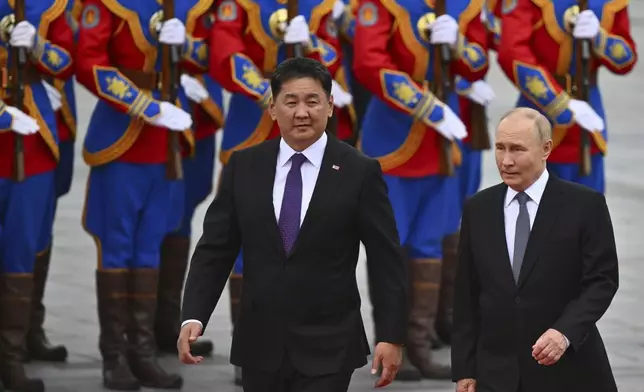 Russian President Vladimir Putin, right, walks with Mongolian President Ukhnaagiin Khurelsukh, left, during a welcoming ceremony at Sukhbaatar Square in Ulaanbaatar, Mongolia, Tuesday, Sept. 3, 2024. (Kristina Kormilitsyna, Sputnik, Kremlin Pool Photo via AP)