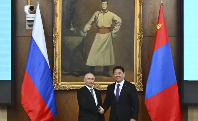 Russian President Vladimir Putin, left and Mongolian President Ukhnaagiin Khurelsukh shake hands as they pose for photos prior to the Russian-Mongolian talks at the Saaral Ordon Government Building in Ulaanbaatar, Mongolia, Tuesday, Sept. 3, 2024. (Kristina Kormilitsyna, Sputnik, Kremlin Pool Photo via AP)