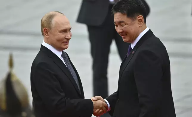 Russian President Vladimir Putin, left, and Mongolian President Ukhnaagiin Khurelsukh shake hands during a welcoming ceremony at Sukhbaatar Square in Ulaanbaatar, Mongolia, Tuesday, Sept. 3, 2024. (Kristina Kormilitsyna, Sputnik, Kremlin Pool Photo via AP)