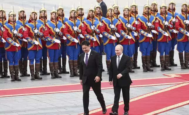 Russian President Vladimir Putin, right, walks with Mongolian President Ukhnaagiin Khurelsukh, left, during welcoming ceremony at Sukhbaatar Square in Ulaanbaatar, Mongolia, Tuesday, Sept. 3, 2024. (Sofya Sandurskaya, Sputnik, Kremlin Pool Photo via AP)