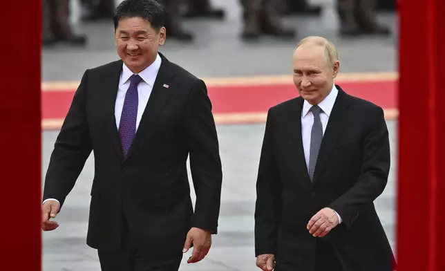 Russian President Vladimir Putin, right, walks with Mongolian President Ukhnaagiin Khurelsukh, left, during welcoming ceremony at Sukhbaatar Square in Ulaanbaatar, Mongolia, Tuesday, Sept. 3, 2024. (Kristina Kormilitsyna, Sputnik, Kremlin Pool Photo via AP)