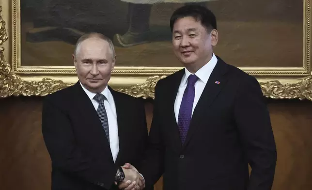 Russian President Vladimir Putin and Mongolian President Ukhnaagiin Khurelsukh shake hands as they pose for photos prior to the Russian-Mongolian talks at the Saaral Ordon Government Building in Ulaanbaatar, Mongolia, Tuesday, Sept. 3, 2024. (Sofia Sandurskaya, Sputnik, Kremlin Pool Photo via AP)