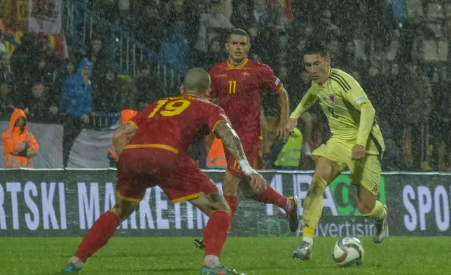 Wales' Harry Wilson, right, duels for the ball with Montenegro's Slobodan Rubezic during the UEFA Nations League soccer match between Montenegro and Wales at the City Stadium, in Niksic, Montenegro, Monday, Sept. 9, 2024. (AP Photo/Risto Bozovic)