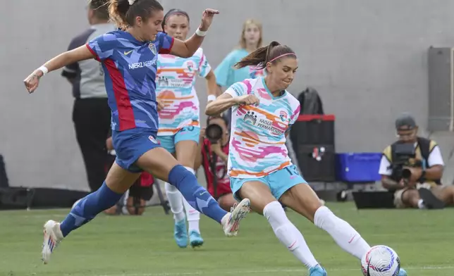 San Diego Wave's Alex Morgan, right, battles for the ball with North Carolina Courages' Malia Berkely during an NWSL soccer on Sunday, Sept. 8 2024, in San Diego. (Sandy Huffaker/The San Diego Union-Tribune via AP)