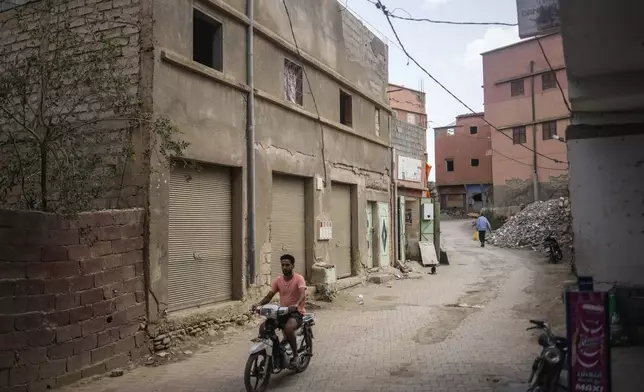 A man drives past a building which was affected by the 2023 earthquake, in the town of Amizmiz, outside Marrakech, Morocco, Wednesday, Sept. 4, 2024. (AP Photo/Mosa'ab Elshamy)