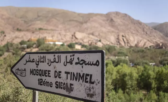 A sign on a road leading to the Great Mosque of Tinmel, which suffered significant damage during a 2023 earthquake, in the Atlas mountain village of Tinmel, outside of Marrakech, Morocco, Thursday, Sept. 5, 2024. Sign reads in Arabic and French "Tinmel Mosque, 12th century." (AP Photo/Mosa'ab Elshamy)