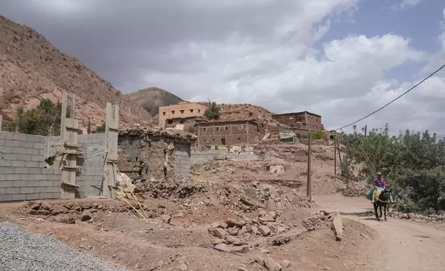 A worker transports construction material on a mule in the village of Tinmel, which suffered significant damage in a 2023 earthquake, in the Atlas mountain village of Tinmel, outside of Marrakech, Morocco, Thursday, Sept. 5, 2024. (AP Photo/Mosa'ab Elshamy)