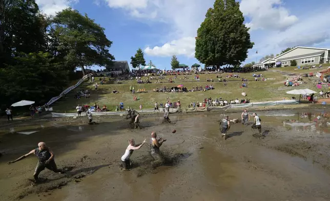 The Muckaneers take on the Muddas' at the 2024 Mud Bowl football game at Hog Coliseum Saturday, Sept. 7, 2024, in North Conway, N.H. (AP Photo/Robert F. Bukaty)