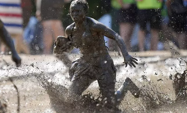 Mahala Smith, of Sabattus, Maine, scrambles for yardage during a women's football game at the Mud Bowl in North Conway, N.H., Saturday, Sept. 7, 3024. (AP Photo/Robert F. Bukaty)