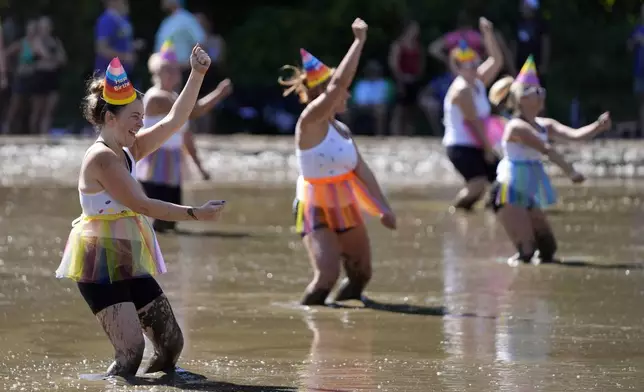 Tori Belkin, foreground, and the Hogettes, entertain the crowd in between football games at the Mud Bowl competition in North Conway, N.H., Saturday, Sept. 7, 3024. (AP Photo/Robert F. Bukaty)