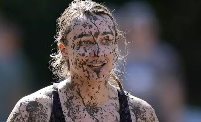 Amanda Lackey, of Bow, N.H., is splattered with mud as she walks back to the huddle during a women's football game at the Mud Bowl in North Conway, N.H., Saturday, Sept. 7, 3024. (AP Photo/Robert F. Bukaty)